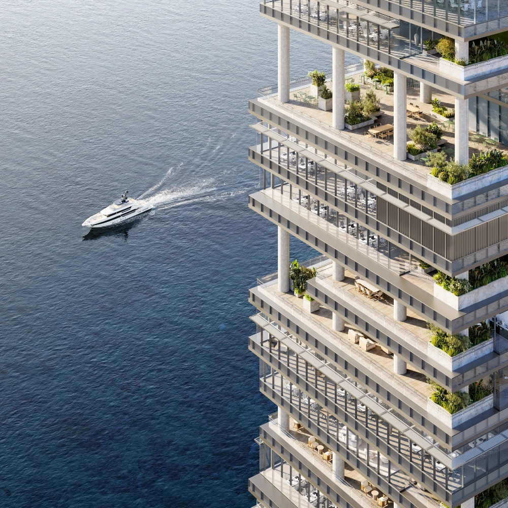 Seafront tower with plant-lined terraces and a yacht passing by, luxury property for sale in UAE
