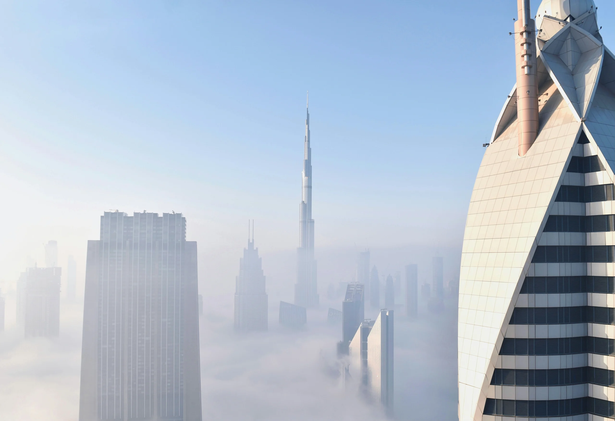 Dubai skyline with Burj Khalifa rising above morning fog